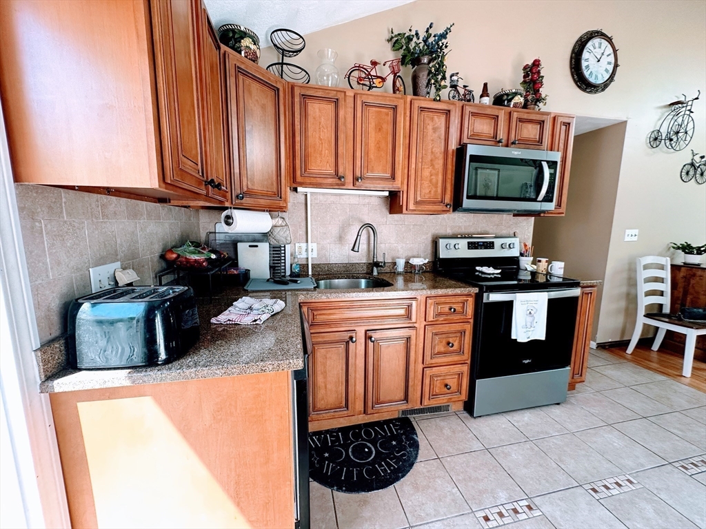4 Mersea Street Saugus, MA 01906 - Photo 10 of 28 a kitchen with stainless steel appliances a stove a sink and a microwave