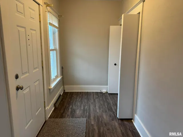 a view of a hallway with wooden floor and a glass door