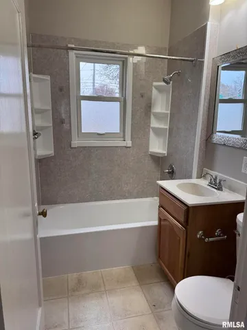 a bathroom with a sink vanity mirror bathtub and toilet
