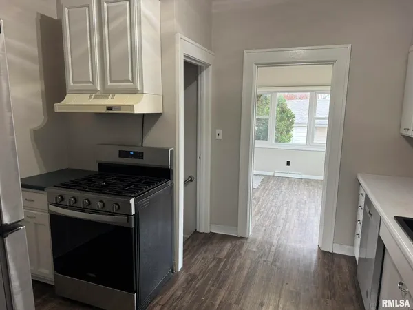 a kitchen with granite countertop wooden floors and stainless steel appliances
