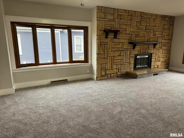 a view of an empty room with a fireplace and a window