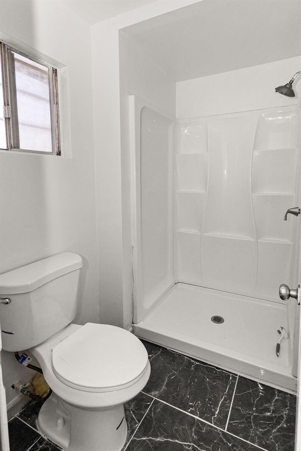 1124 Lakewood Avenue Modesto, CA 95355 - Photo 33 of 40 a bathroom with a toilet and a shower