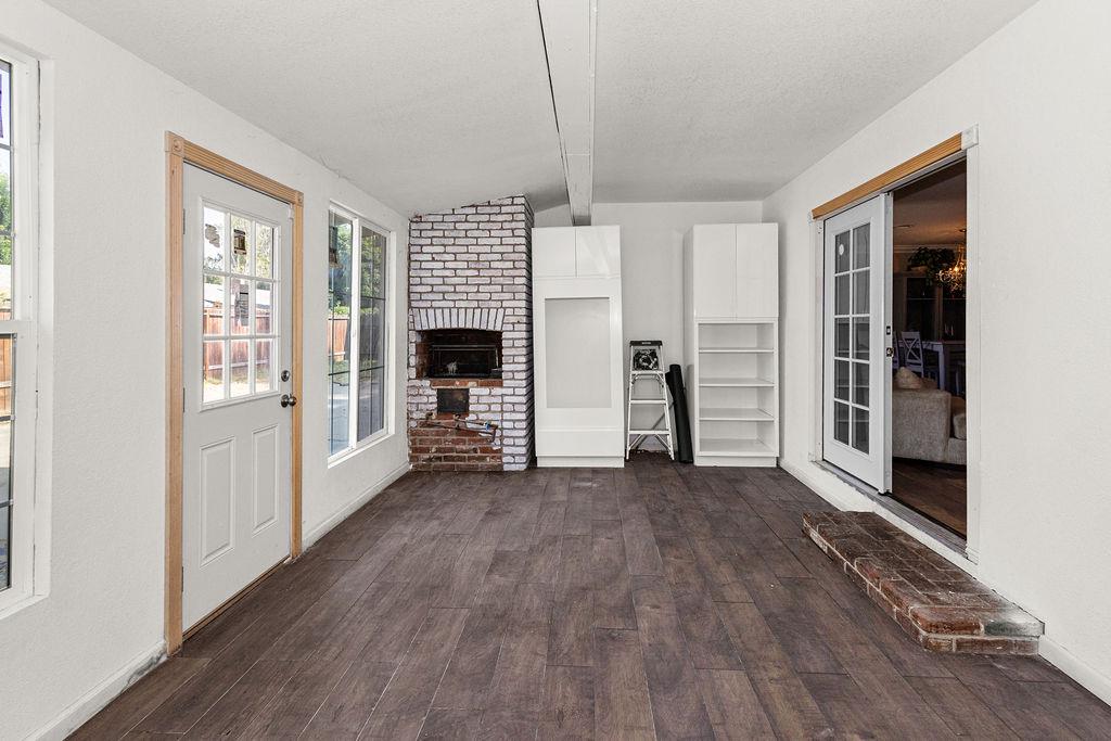 1124 Lakewood Avenue Modesto, CA 95355 - Photo 36 of 40 a view of empty room with wooden floor and fireplace