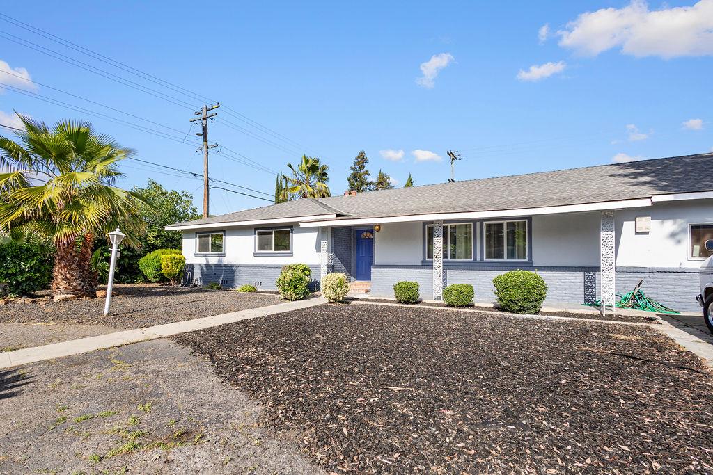 1124 Lakewood Avenue Modesto, CA 95355 - Photo 4 of 40 a front view of a house with a yard and potted plants