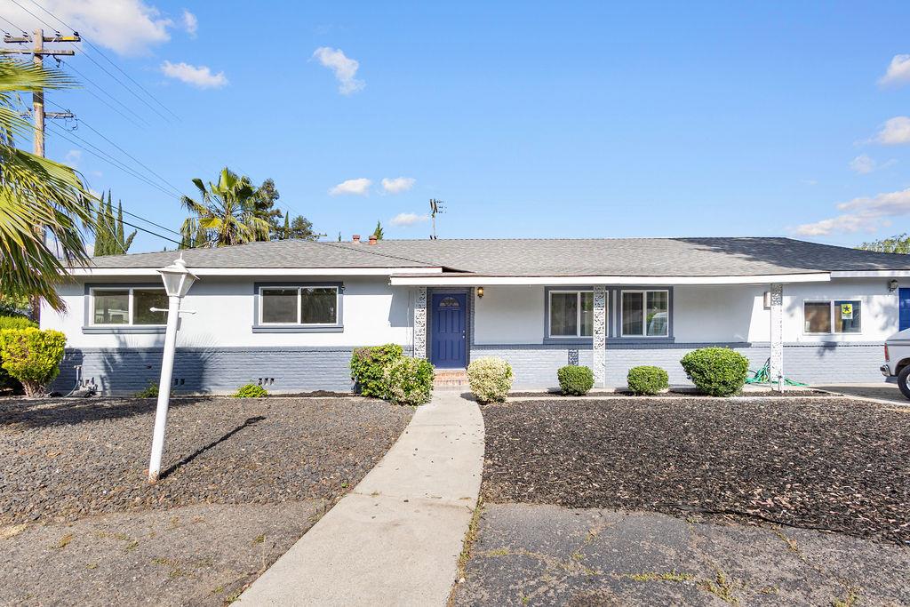 1124 Lakewood Avenue Modesto, CA 95355 - Photo 5 of 40 a front view of a house with a yard and potted plants