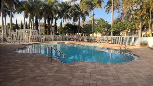 a view of a house with a yard and palm trees