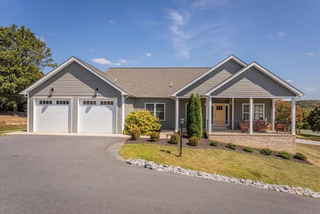 a front view of a house with a yard outdoor seating and garage