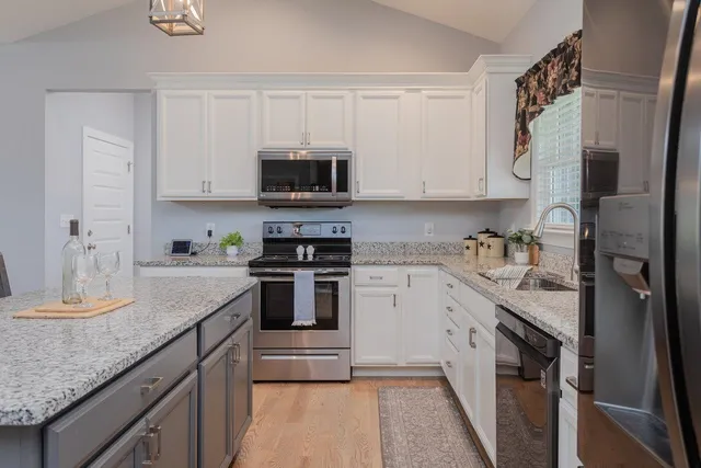 a kitchen with a sink a microwave and cabinets
