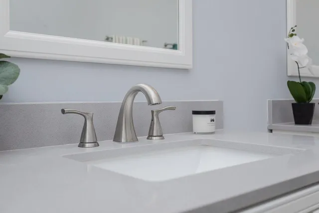 a bathroom with a granite countertop sink a toilet and shower
