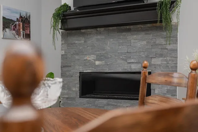 a kitchen with stainless steel appliances granite countertop a stove a refrigerator a kitchen island a sink dishwasher a dining table and chairs with wooden floor