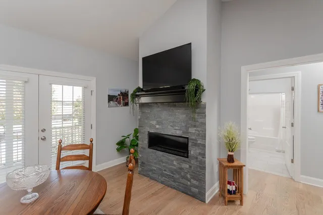 a open kitchen with stainless steel appliances granite countertop a stove top oven a sink dishwasher a dining table and chairs with wooden floor