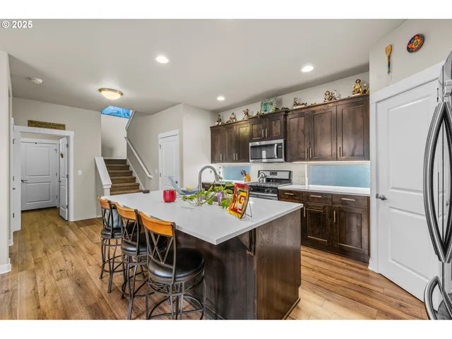 a kitchen with kitchen island wooden cabinets and refrigerator