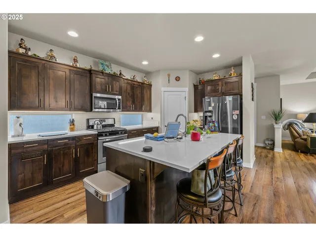 a kitchen with kitchen island granite countertop a sink appliances and cabinets