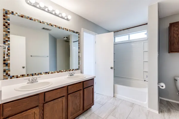 a bathroom with a double vanity sink mirror and shower