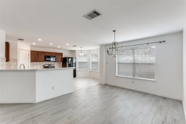 a view of kitchen with stainless steel appliances refrigerator oven and cabinets