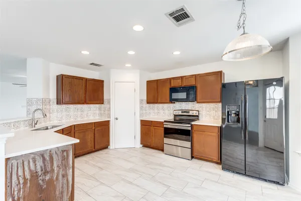 a large kitchen with stainless steel appliances granite countertop a sink stove and refrigerator