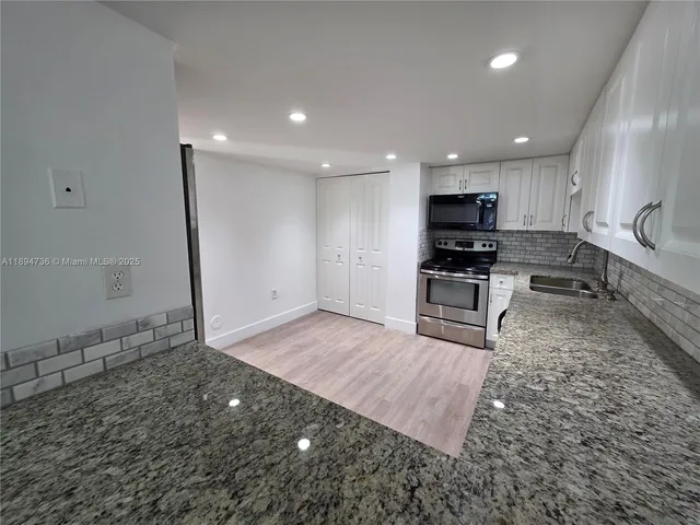 a view of a kitchen with microwave and cabinets