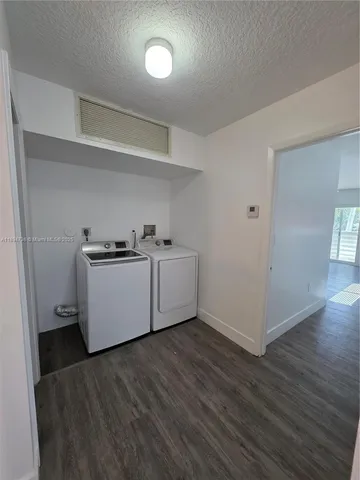 a view of a kitchen with wooden floor and electronic appliances