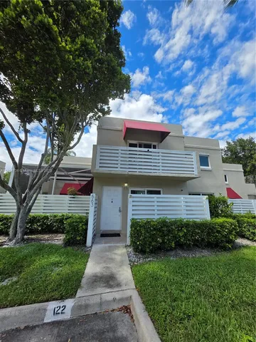 a front view of house with a garden