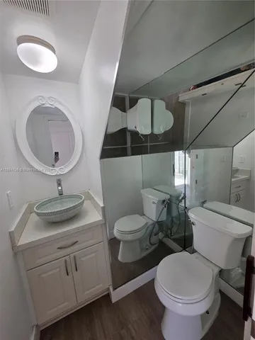 a bathroom with a granite countertop toilet sink and mirror