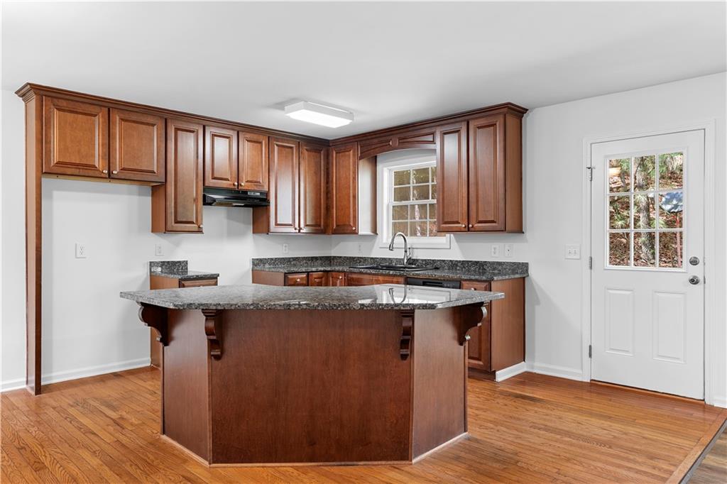 80 Castle Court Ellijay, GA 30540 - Photo 3 of 31 a kitchen with stainless steel appliances granite countertop a stove a sink dishwasher and a microwave oven with wooden floor