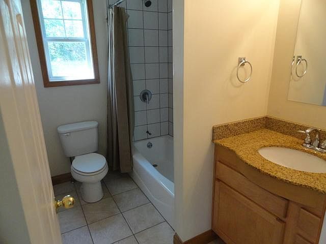2580 Van Dyke Road Minooka, IL 60447 - Photo 27 of 32 a bathroom with a granite countertop toilet a sink and a window