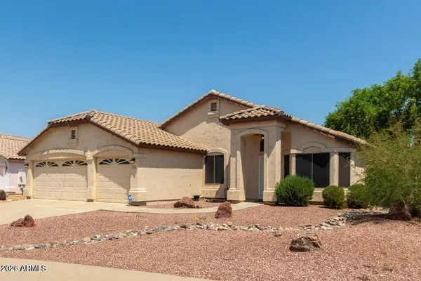 a front view of a house with a dirt yard and garage