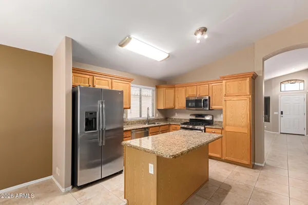 a kitchen with stainless steel appliances granite countertop a refrigerator stove and sink