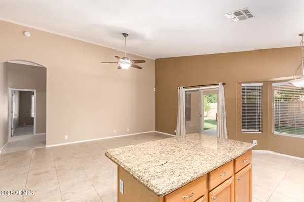 a room with kitchen island and stainless steel appliances
