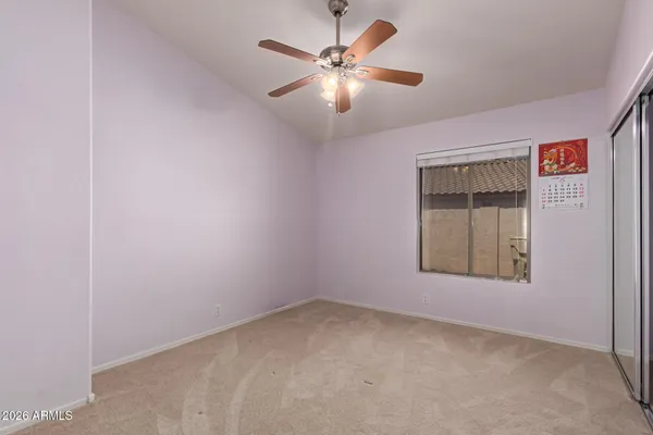 an empty room with windows and fan