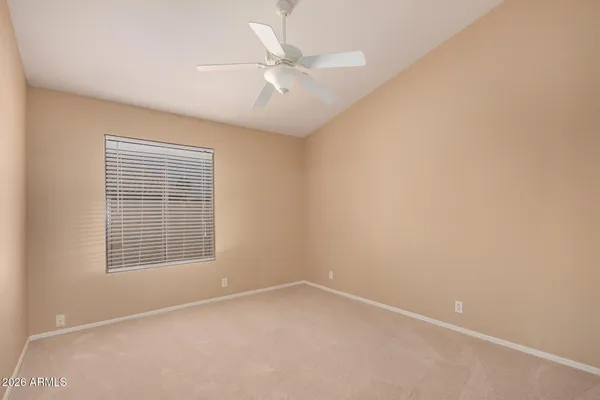 an empty room with a window and a fan