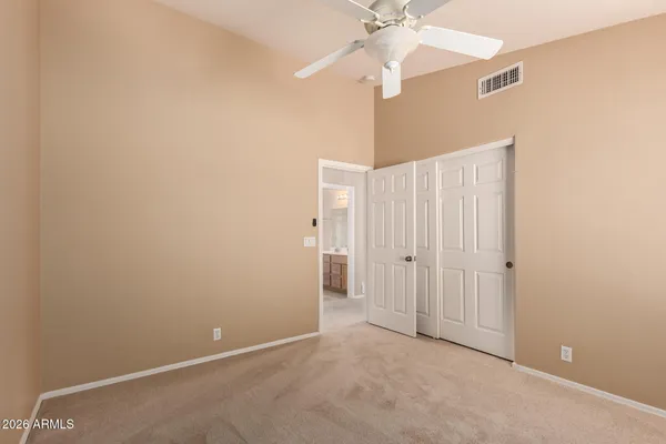 an empty room with a fan and a fan