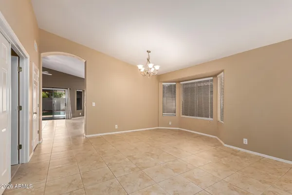 en empty room with windows and chandelier
