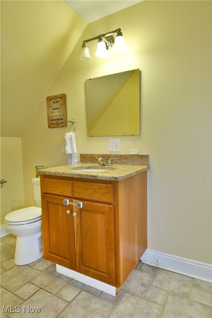 1735 Pleasant Valley Road Girard, OH 44420 - Photo 31 of 44 Bathroom featuring vaulted ceiling, baseboards, toilet, and vanity