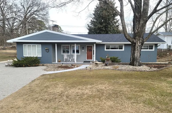 a front view of a house with yard and green space