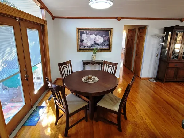 a kitchen with stainless steel appliances a table chairs refrigerator and microwave