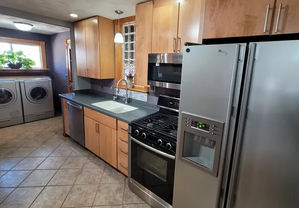 a kitchen with granite countertop a stove a sink and a microwave