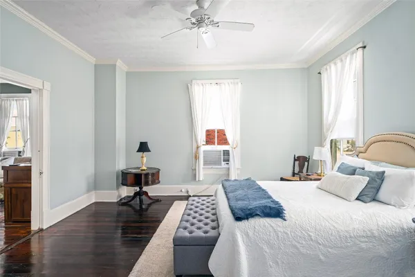 a bedroom with a bed wooden floor and a table