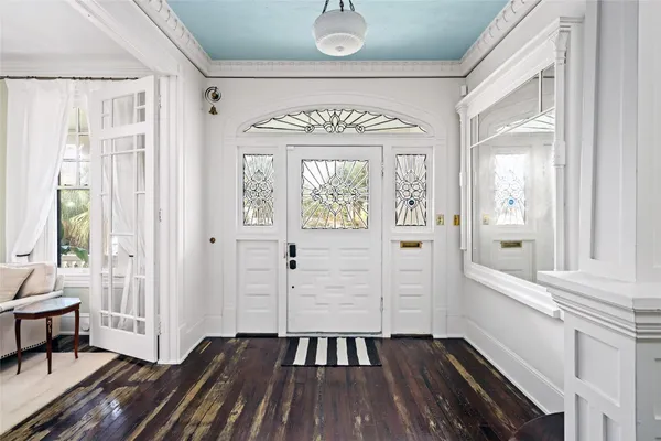 a view of a hallway with wooden floor and windows