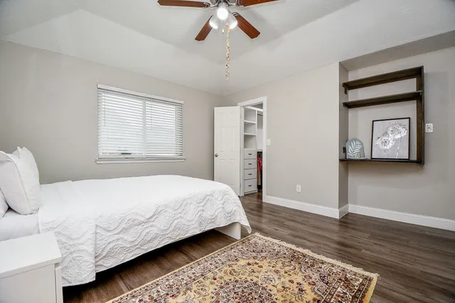 a bedroom with a bed rug and wooden floor