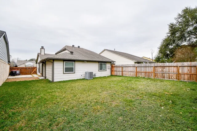 a view of a backyard with table and chairs and wooden fence