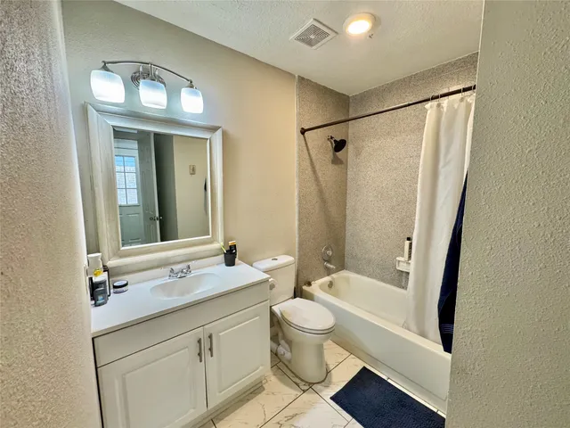 a backyard of a house with wooden fence and a bench