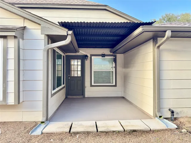 a backyard of a house with table and chairs
