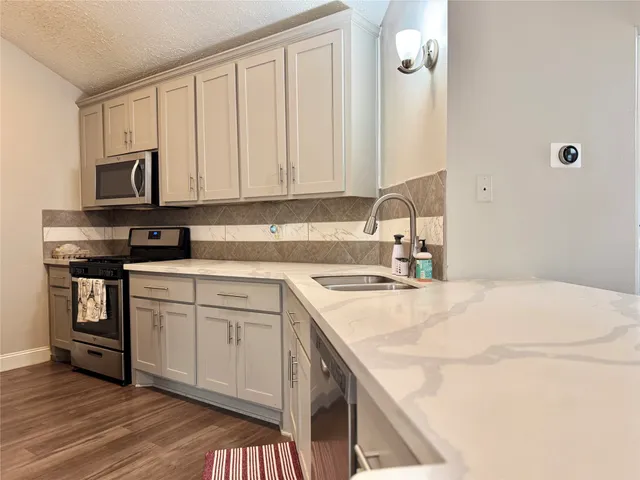 a kitchen with a refrigerator and a stove top oven
