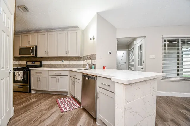 a kitchen with stainless steel appliances granite countertop a refrigerator and a stove