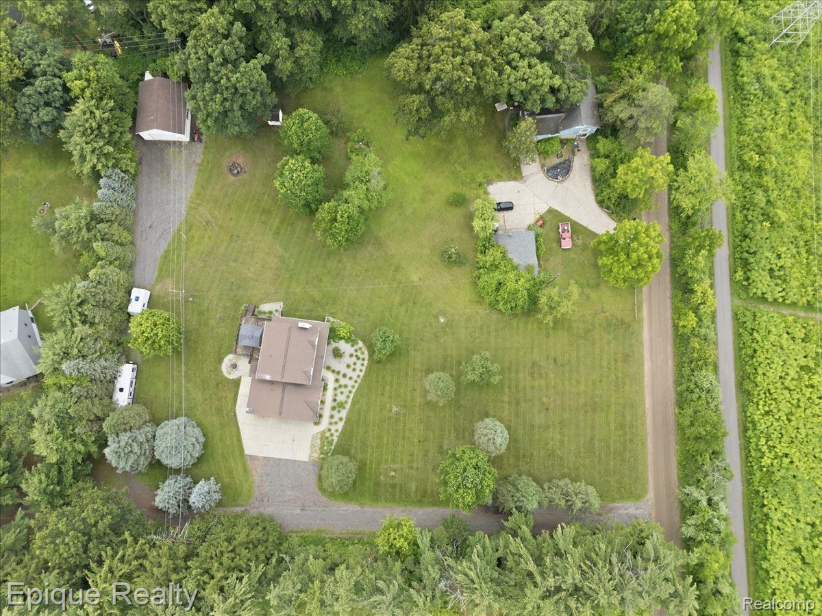 1221 Rhodes Road Lake Orion, MI 48360 - Photo 68 of 72 Expansive property featuring multiple structures, mature trees, gravel driveways, and surrounding greenery