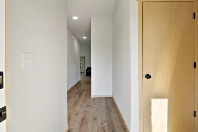 a view of a hallway with wooden floor