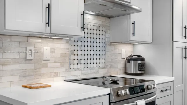 a kitchen with white cabinets and sink