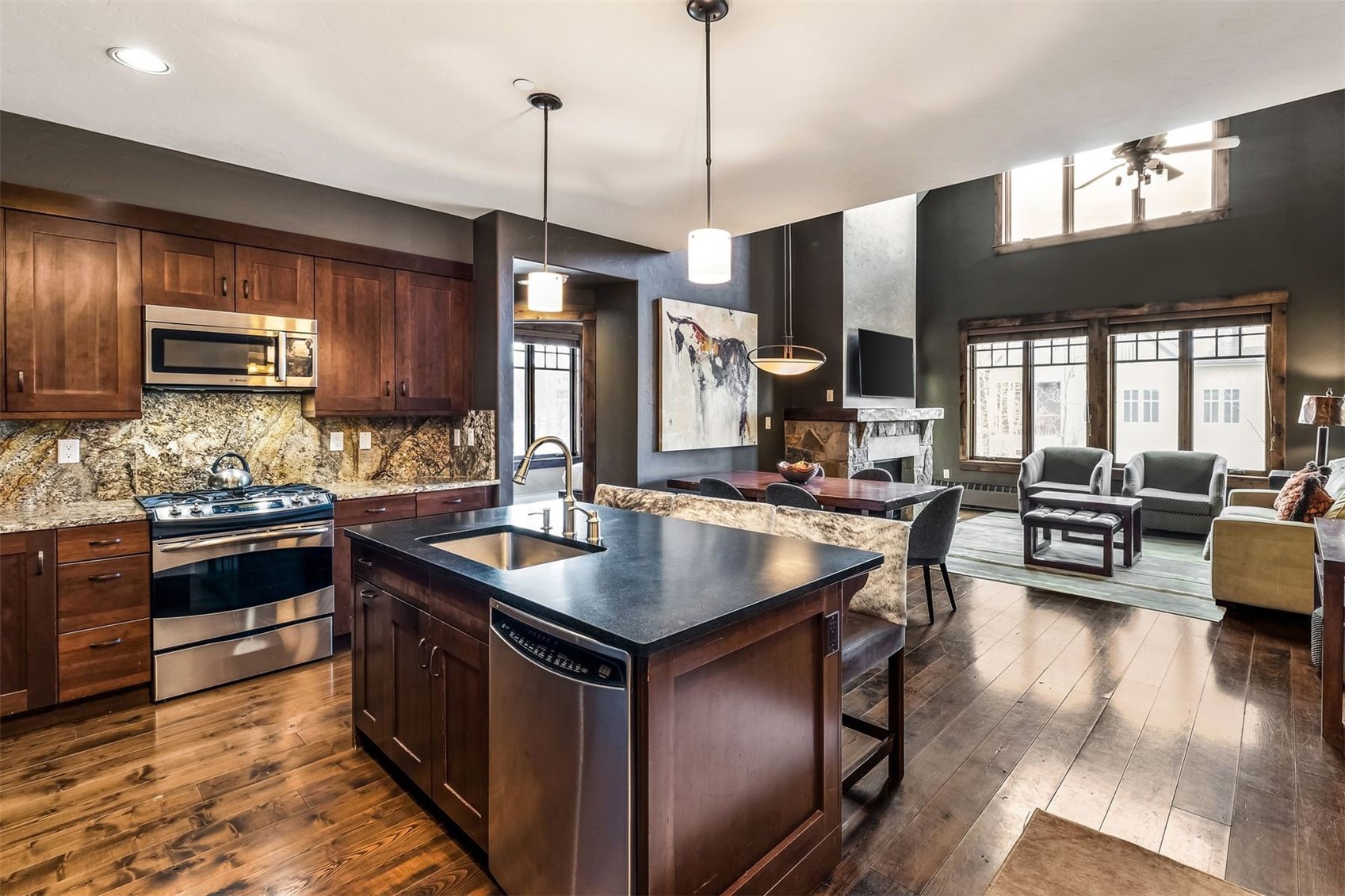 600 Columbine Road, Unit 5305 Breckenridge, CO 80424 - Photo 3 of 36 a kitchen with stainless steel appliances granite countertop a stove a sink a oven a dining table and chairs with wooden floor