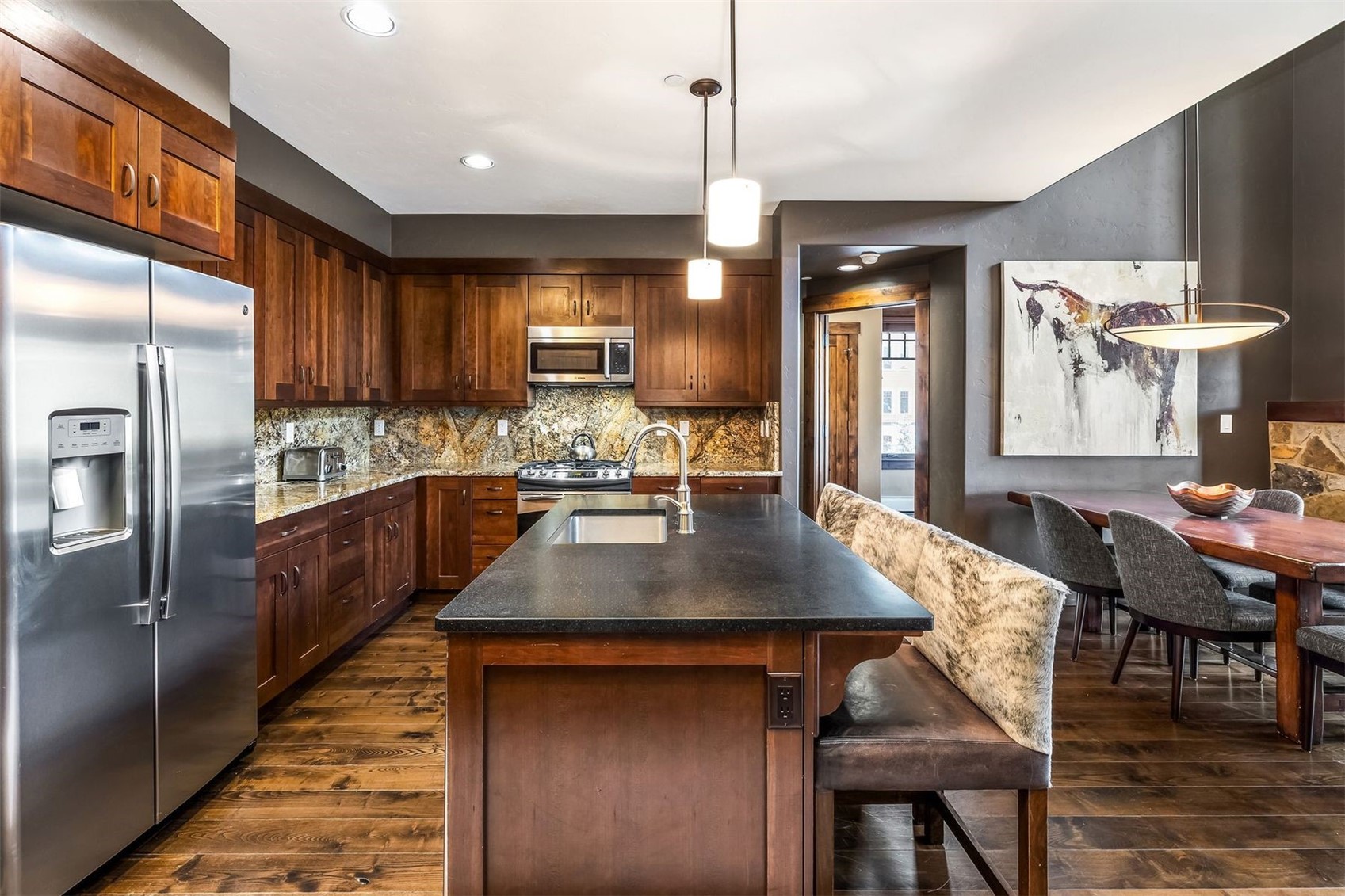 600 Columbine Road, Unit 5305 Breckenridge, CO 80424 - Photo 4 of 36 a kitchen with stainless steel appliances kitchen island granite countertop a table chairs and a refrigerator